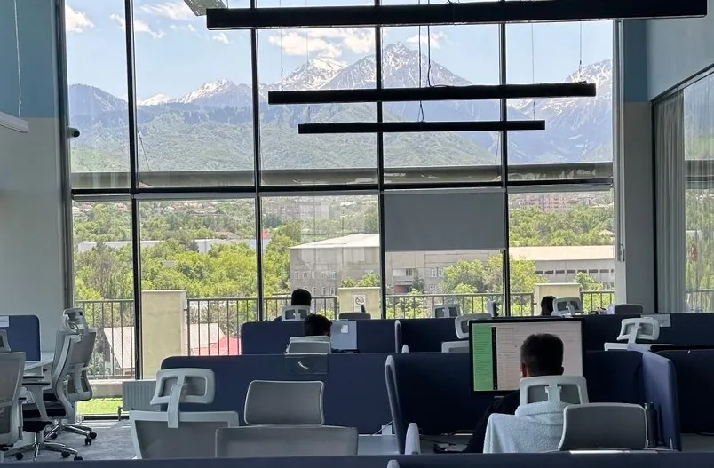 Open-plan desks in the Fortis office with a mountain view through the glazing