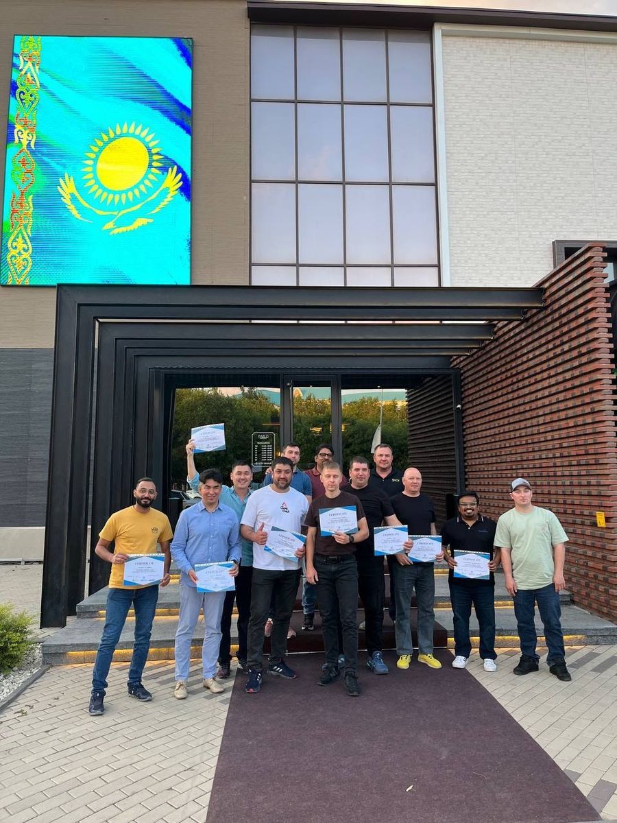 ABSS team outside the office holding training certificates